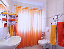 an orange room with a sink and a mirror